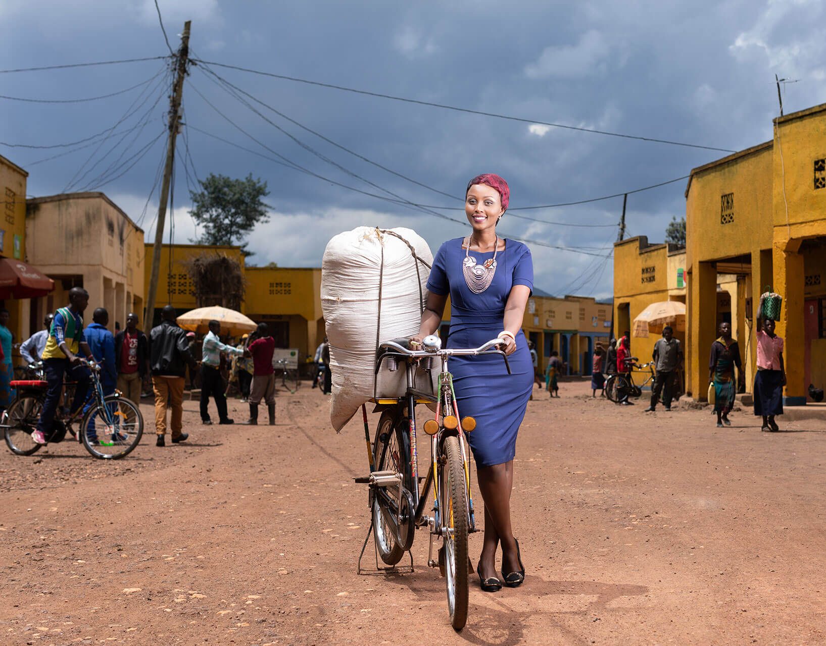 Lady with bike with bag of crop in African street