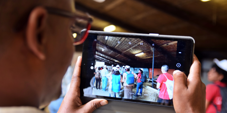 Man taking photos of his group during a farm visit