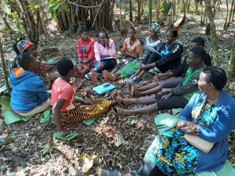 Burundian women sitting under the trees for training