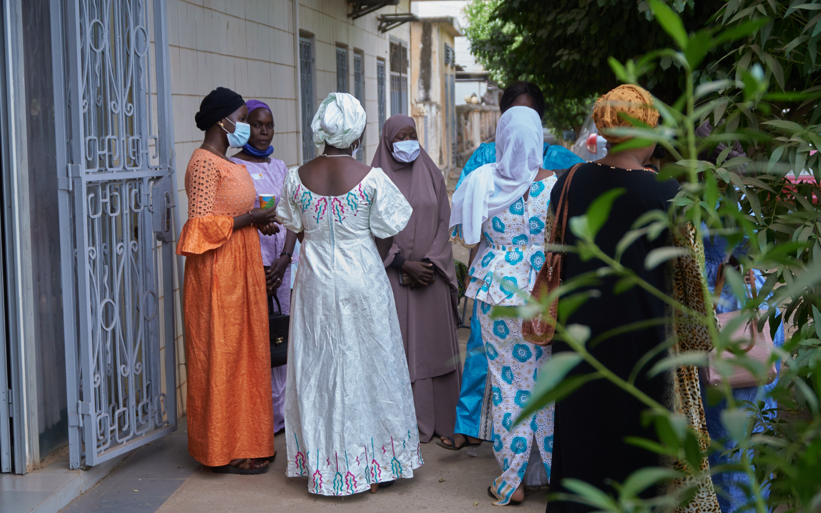 Malian women in colourful clothing gathered in a circle