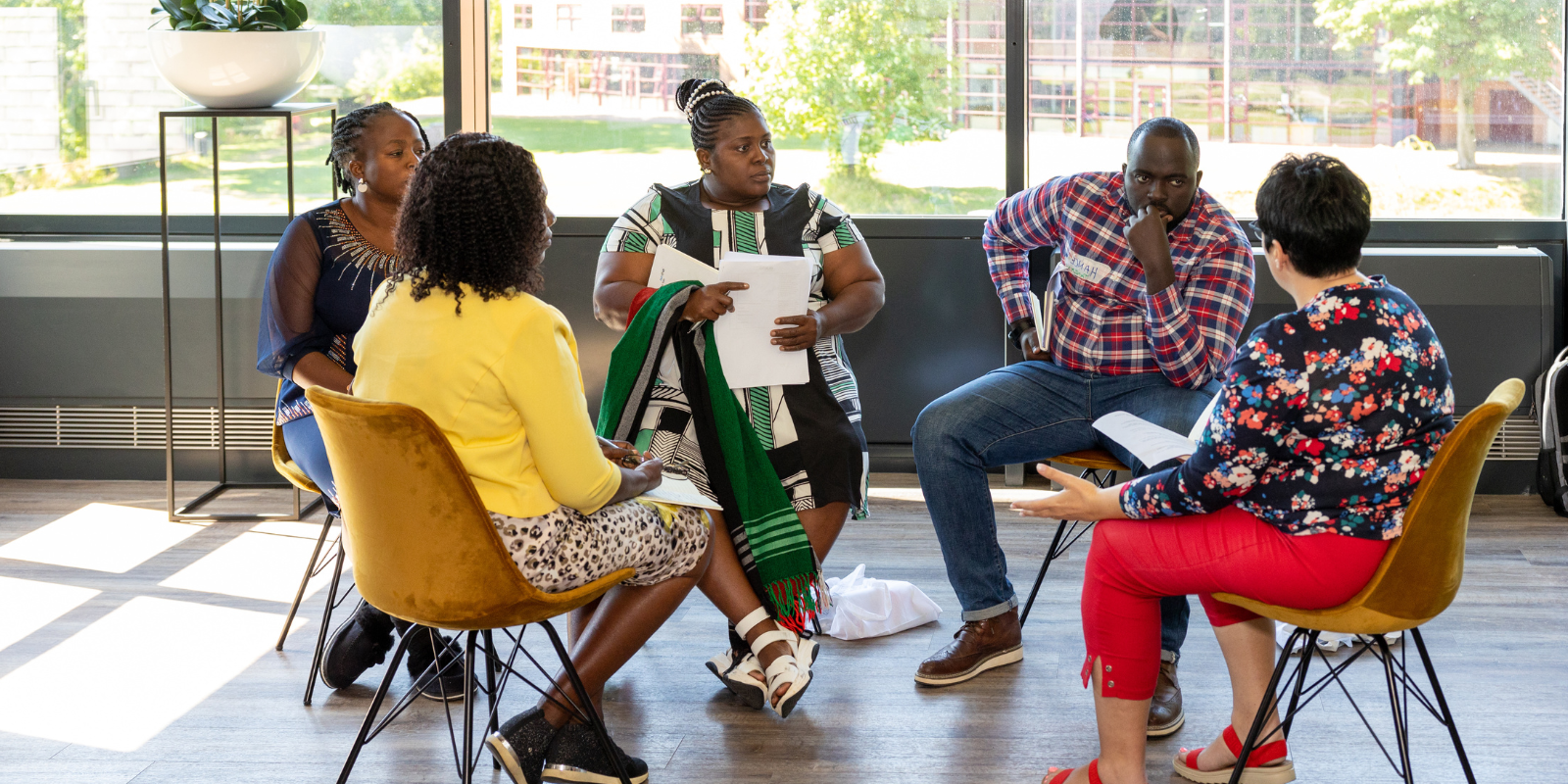 A team working together, discussing in a circle of chairs during and iCRA training in Wageningen.